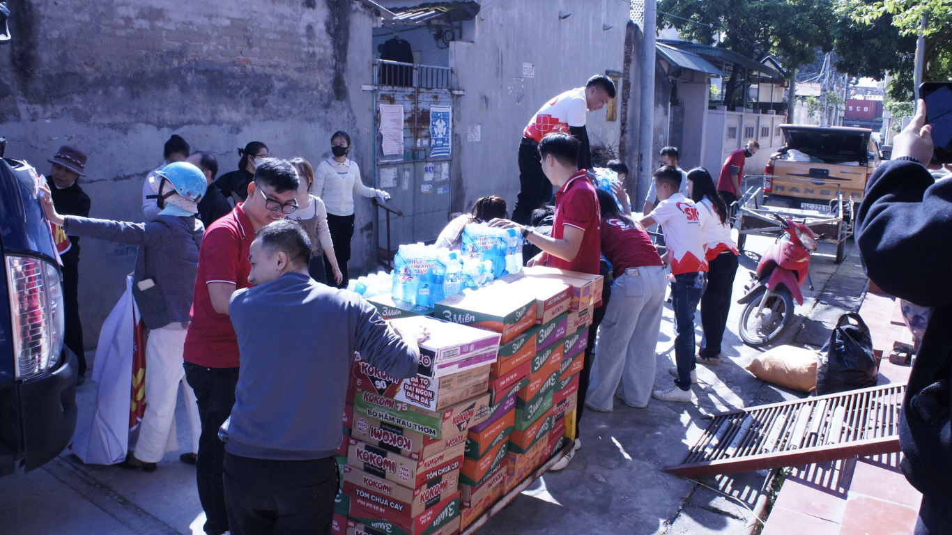 Đội ngũ SK cùng các tình nguyện viên hỗ trợ di chuyển nhu yếu phẩm lên xe tải